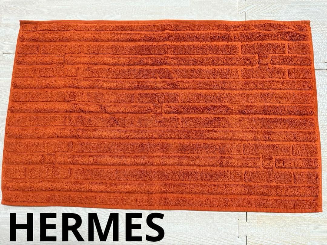 エルメス（HERMES）のHロゴ入りデザインのオレンジ色のコットン